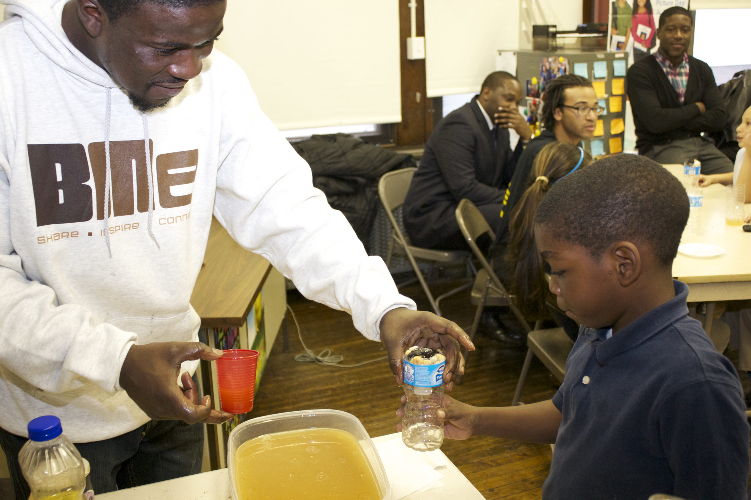 BMe organizer Alex Peay (left) tests a student-built water filter.