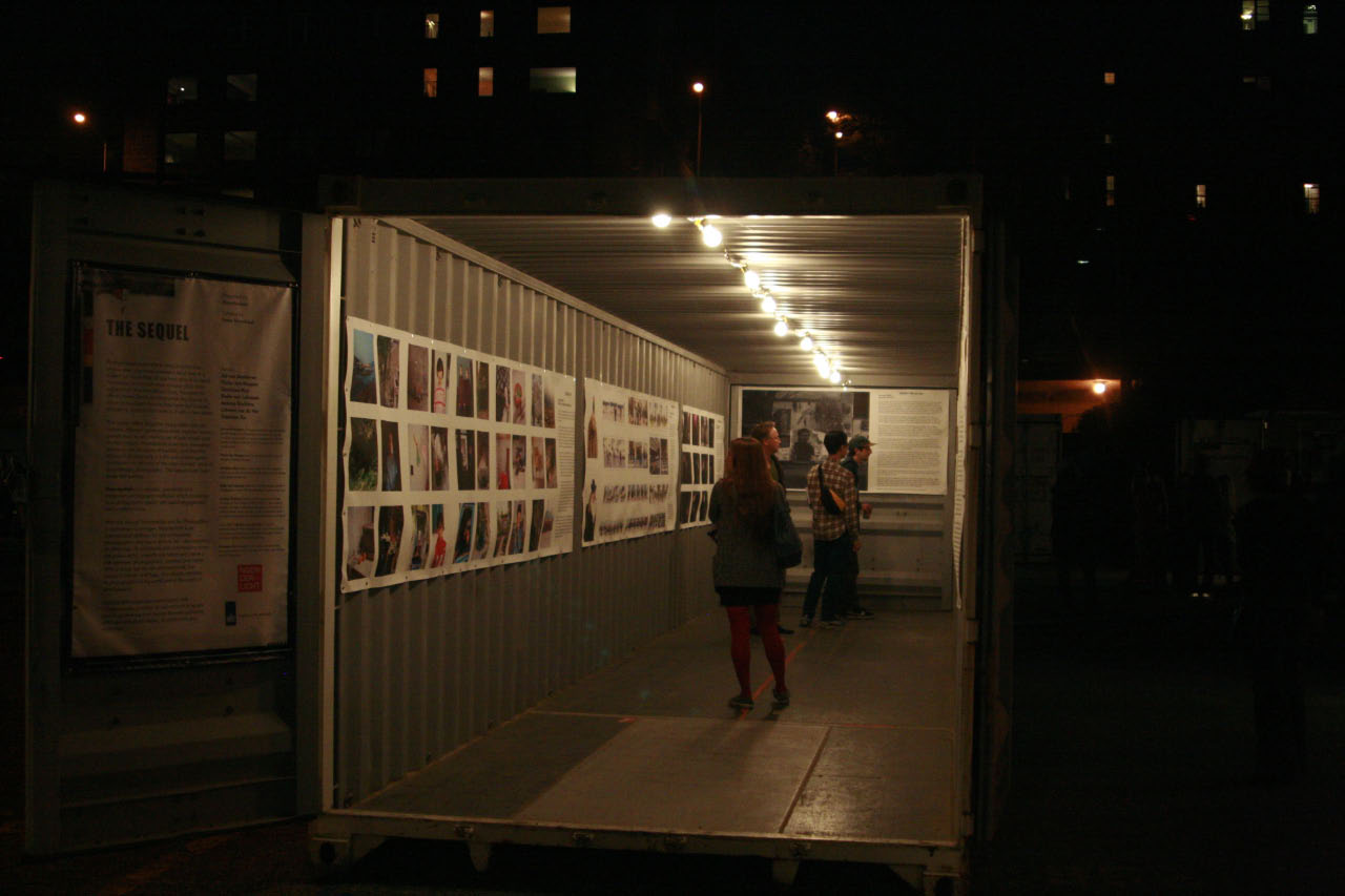 A guest looking at one of the container’s exhibitions,  “The Sequel,” at Photoville 2013