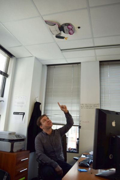 Turk points to the Sunlight Lab's unofficial mascot above his desk: a robot. (Photo by Ashley Nguyen)