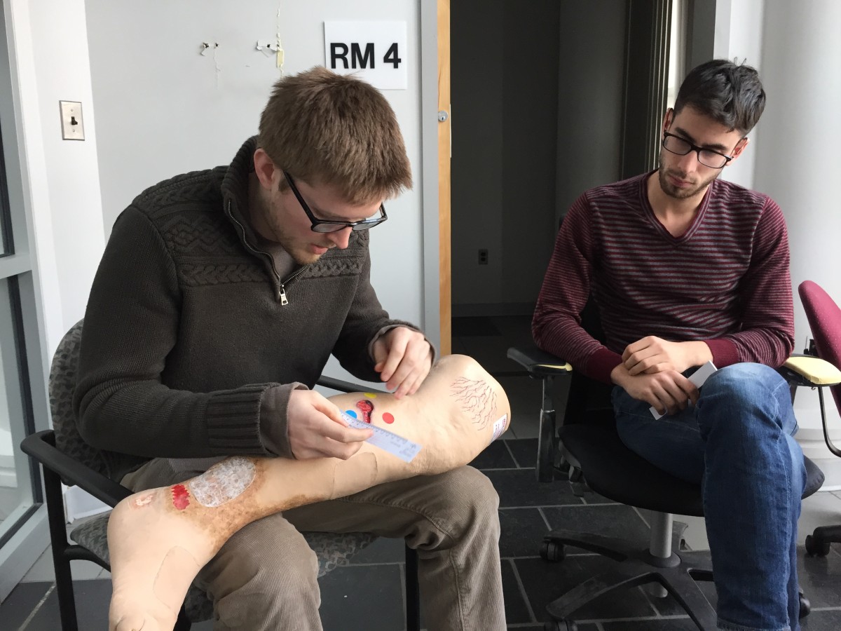 Tissue Analytics’ Kevin Keenahan (left) and Josh Budman demonstrate old-school wound measurement techniques.