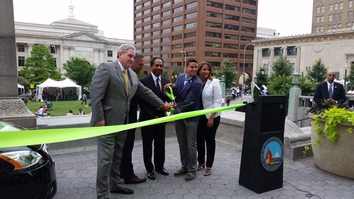 Cutting the bright green Zipcar ribbon at Rodney Square.