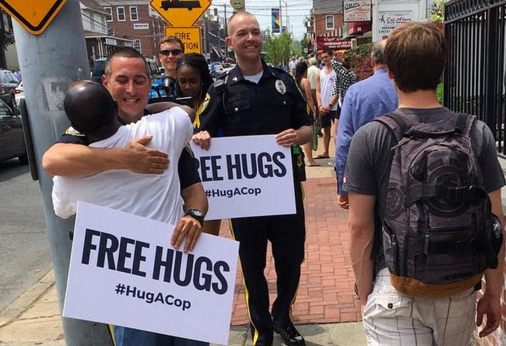 Officers James Spadola (center) and Aaron Olicker give out free hugs in Newark.