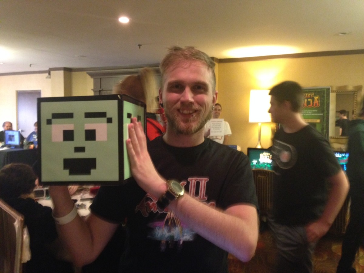 Matt Sharp holds Cubey, a character in Sharp's mobile game, "Cubey Sphere."
