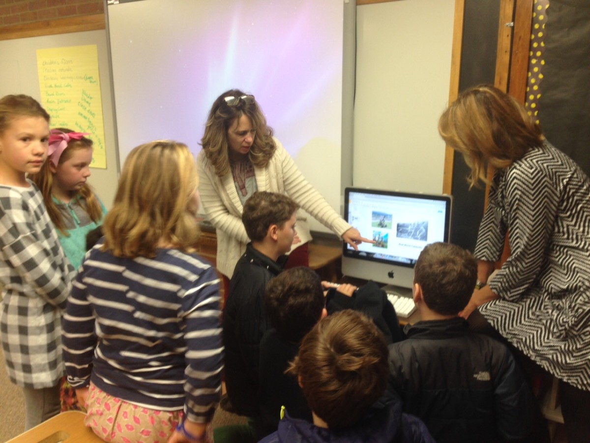 Tatnall students gather around a computer screen with pictures of catapults both new and old. Teachers Heather Brooks (left) and Colleen Hobart (right) helped create the space.