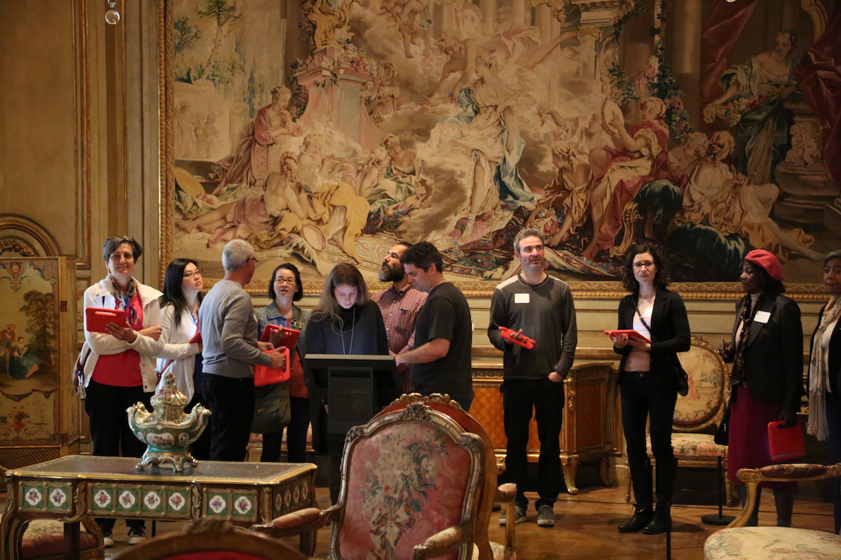 A group, tablets in hand, tours the Philadelphia Museum of Art.