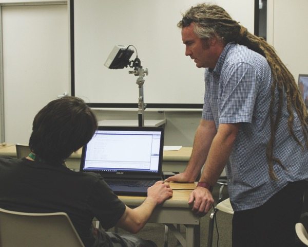 Scott Shaw helps one of his students at Wilmington University.