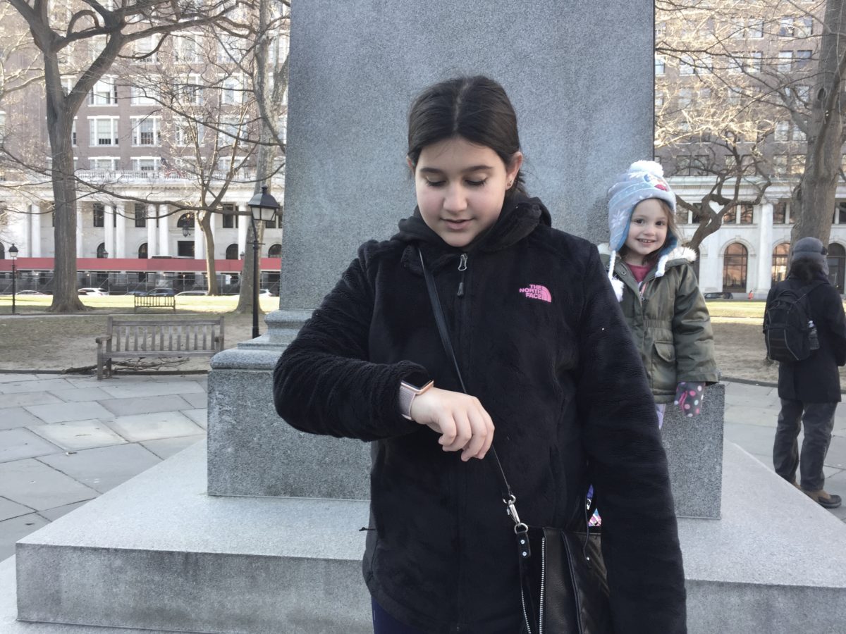 My 10-year-old cousin, pretending to look at her Apple Watch, while her little sister looks on.