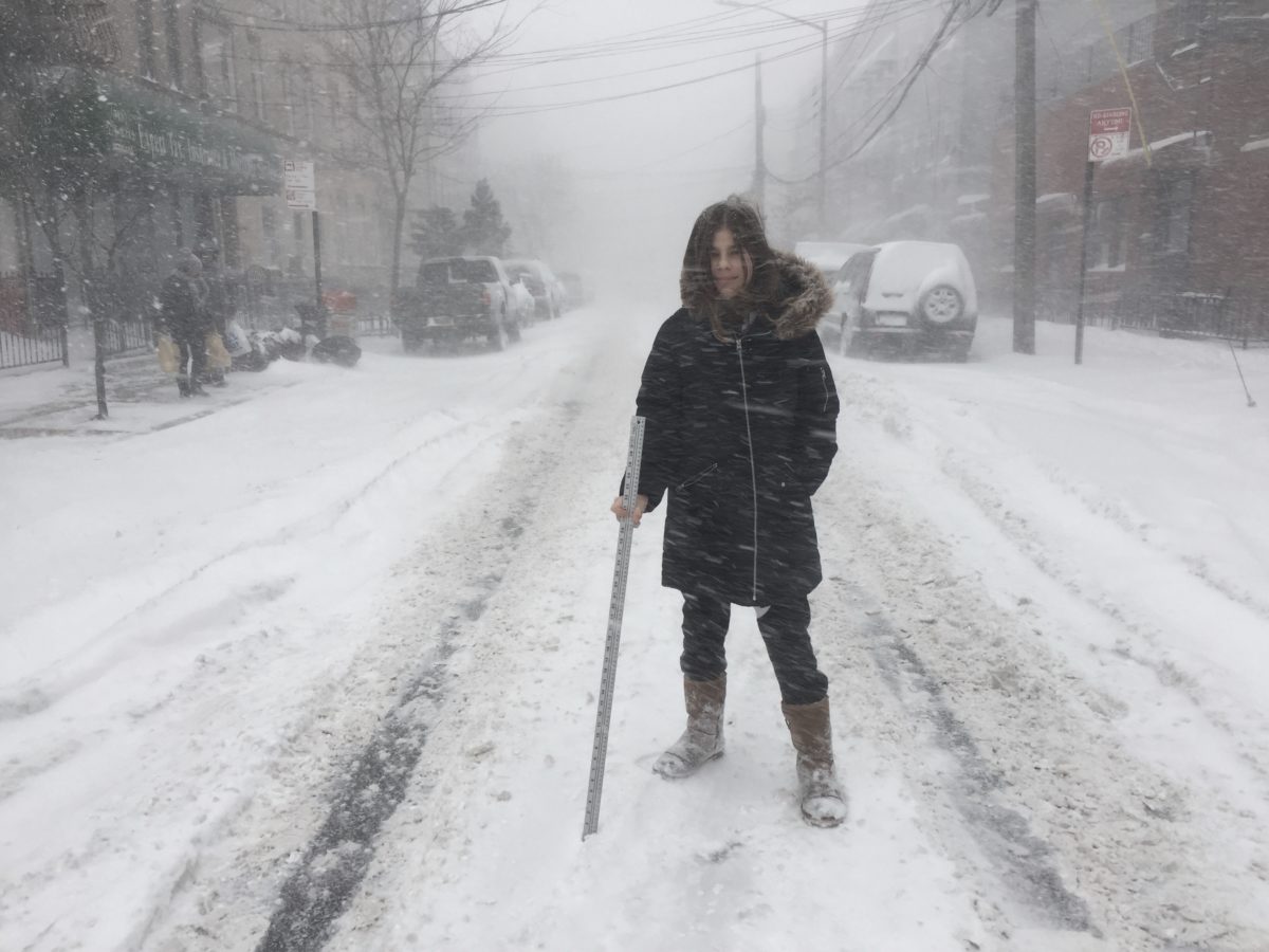 Honorary Technical.ly Brooklyn Editorial Assistant Audrey Gardner, 11, measures the snow accumulation on Driggs Avenue, Jan. 4, 2018.