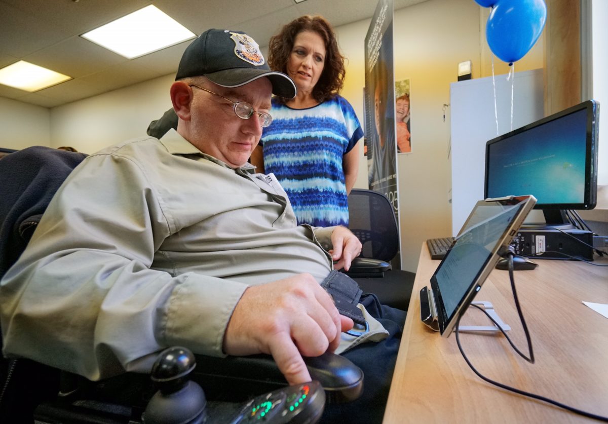 A person with disability uses a tablet at the SPIN community center.
