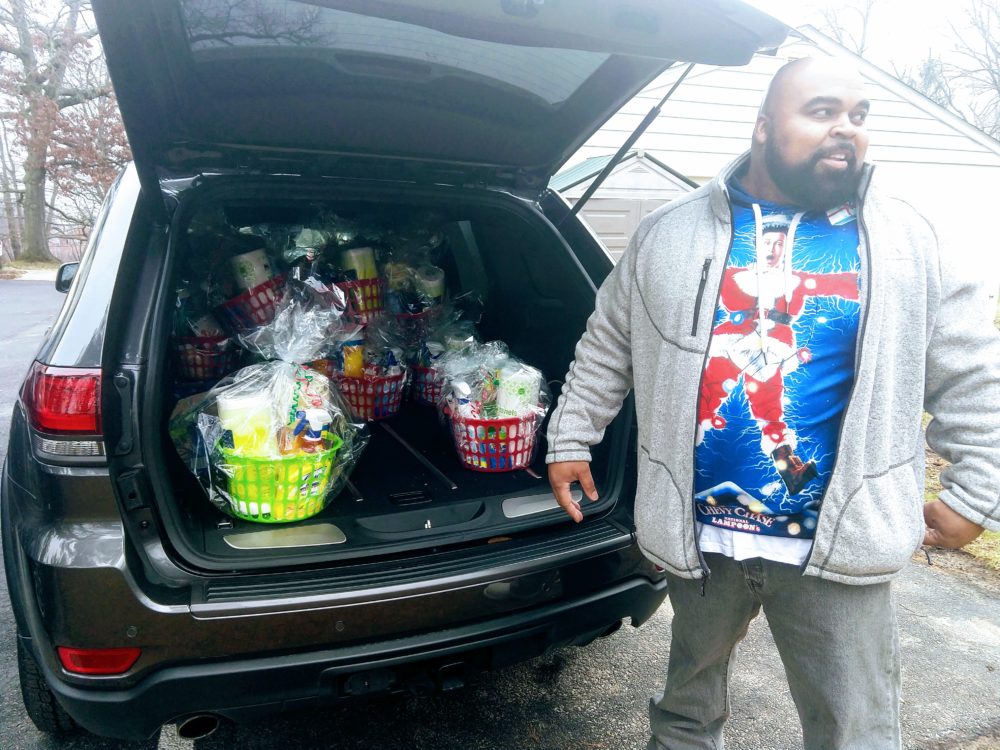 A volunteer helps unload gifts for homeless families.