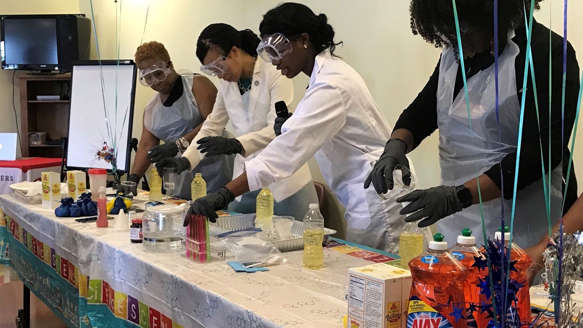 Congresswoman Blunt-Rochester and Jacqueline Means (center, left to right) conduct an experiment at the first Girls Empowerment STEM event.