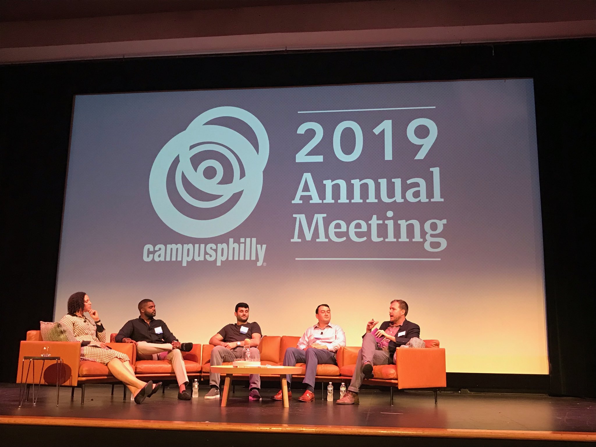 Five people in chairs with the Campus Philly logo on the screen