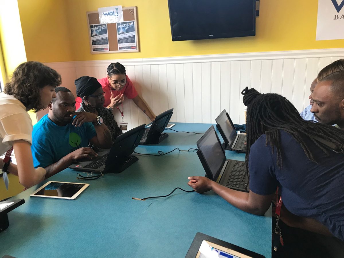 Librarians helping customers with computer skills.