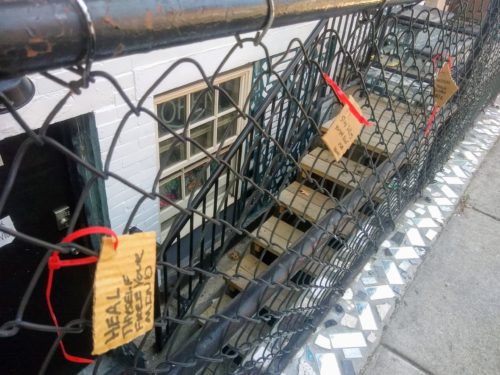 Guests leave messages like padlocks on a chain link fence.