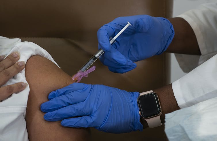 A patient care director in New York receives the coronavirus vaccine.