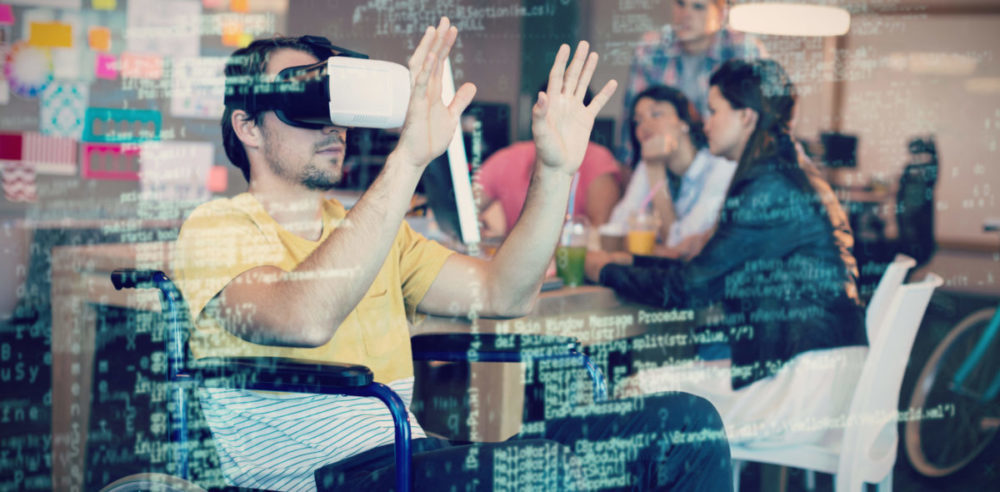 A man sits in a wheelchair while using a VR headset. An overlay features coding text