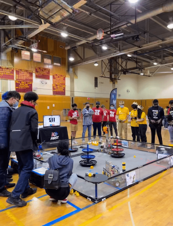 Students and referees stand around the RoboJawn competition ring.