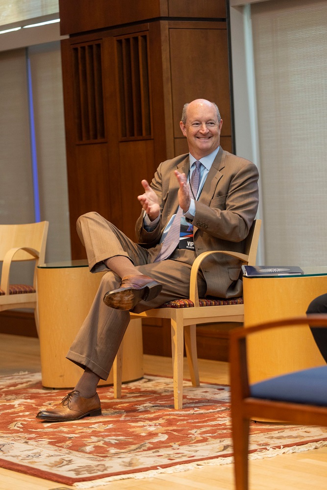 David Cole sitting in a chair, clapping.