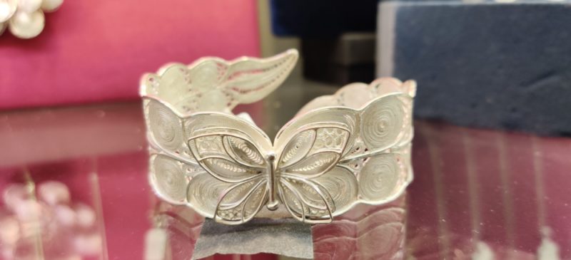 A silver bracelet in the shape of a butterfly from a local maker