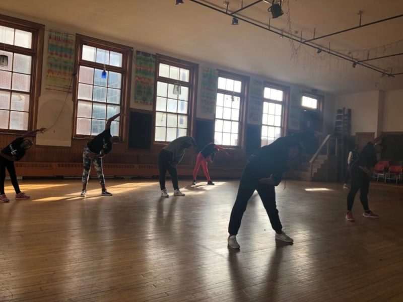 Students in a dance studio, stretching