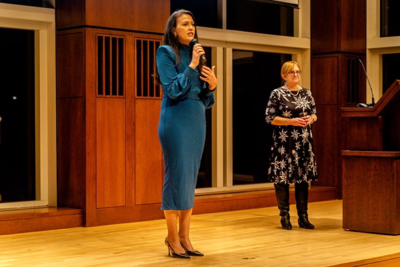 A woman in a blue dress standing next to a woman in a blue dress.