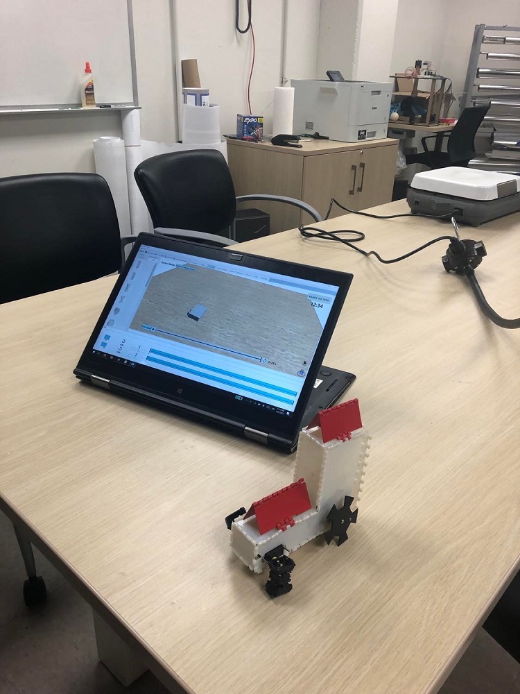 Built-a-Bot on an iPad with a robot sitting next to it. 