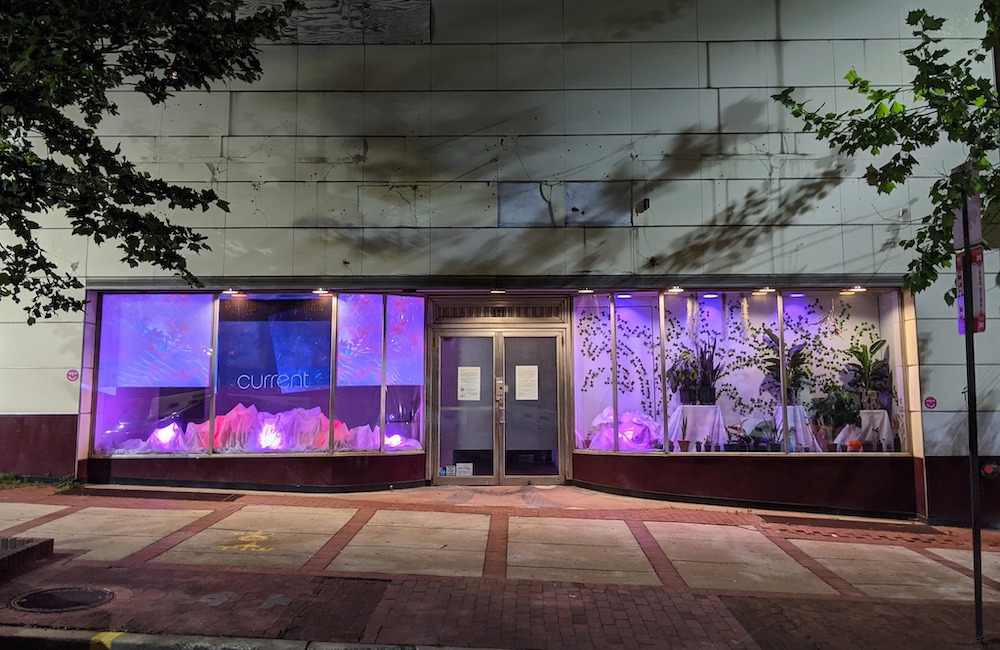 Luzes roxas na instalação de arte no prédio cinza