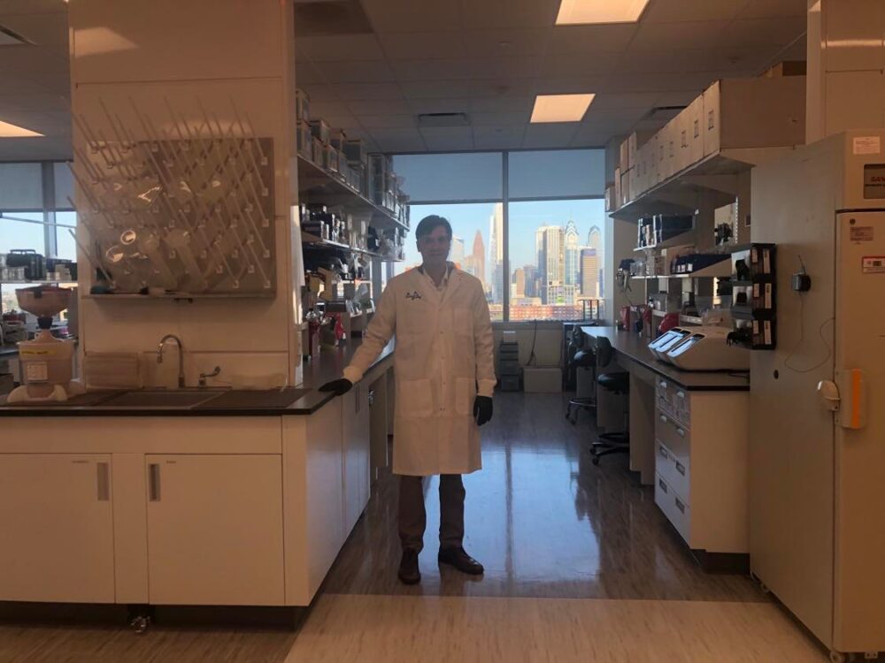 Kyle Doolan wearing a lab coat in the lab.