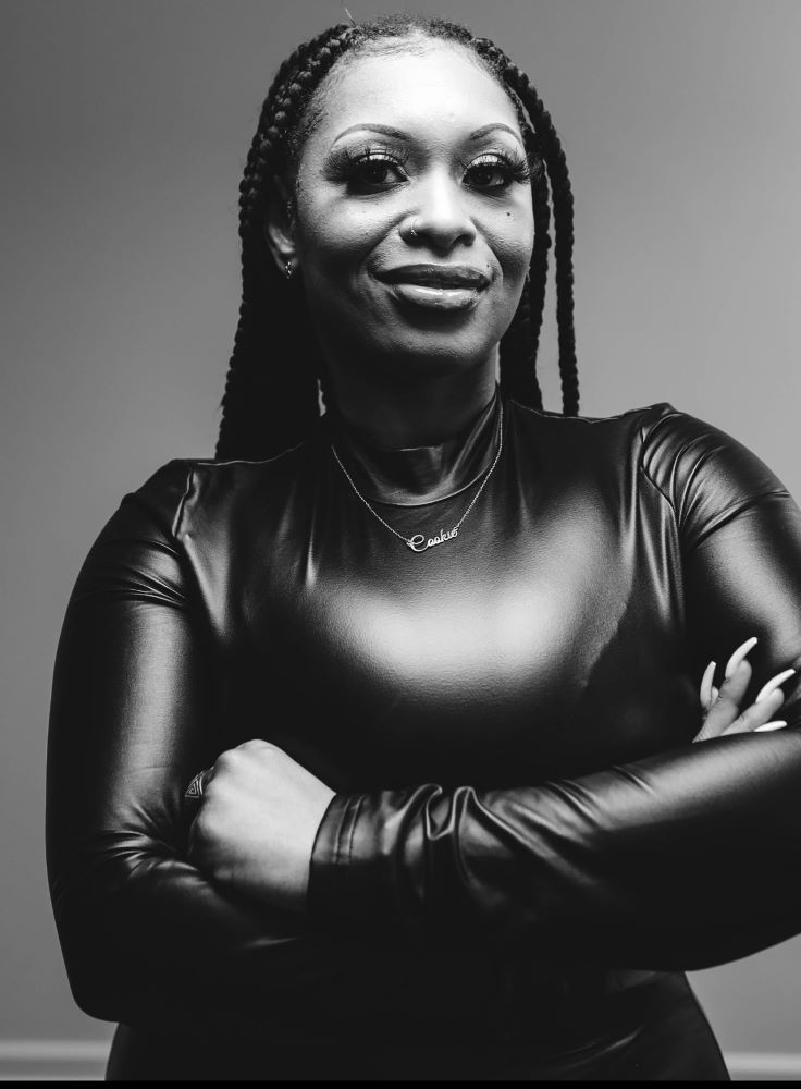 A waist-up shot of Portia Williams, who poses in a black dress.