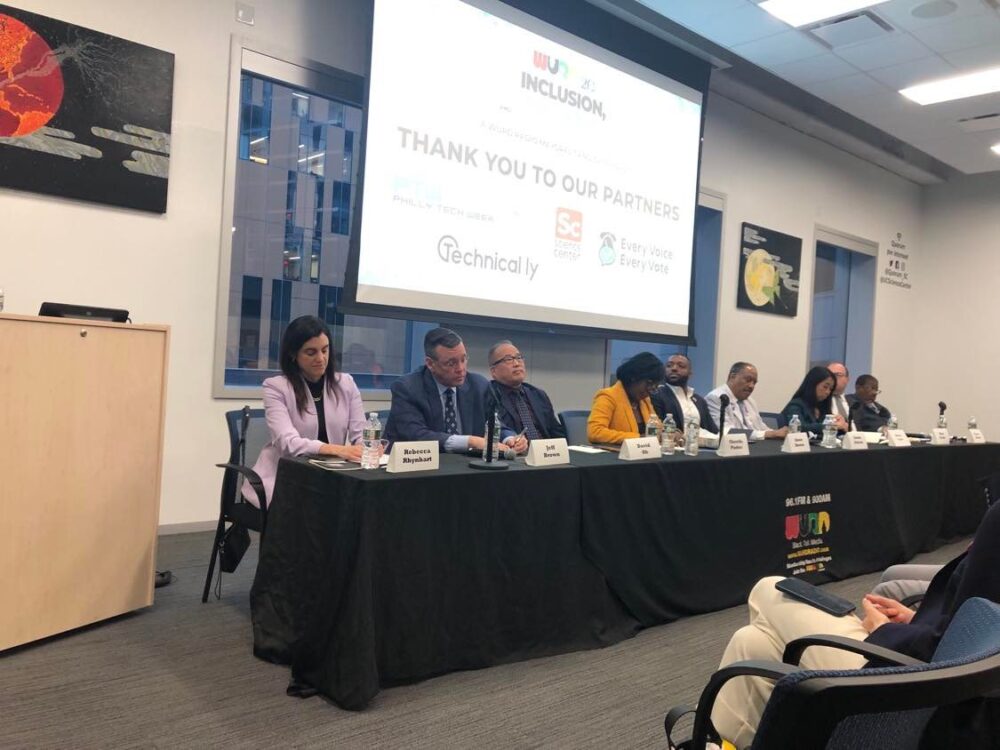 Mayoral candidates sitting at a panel table.