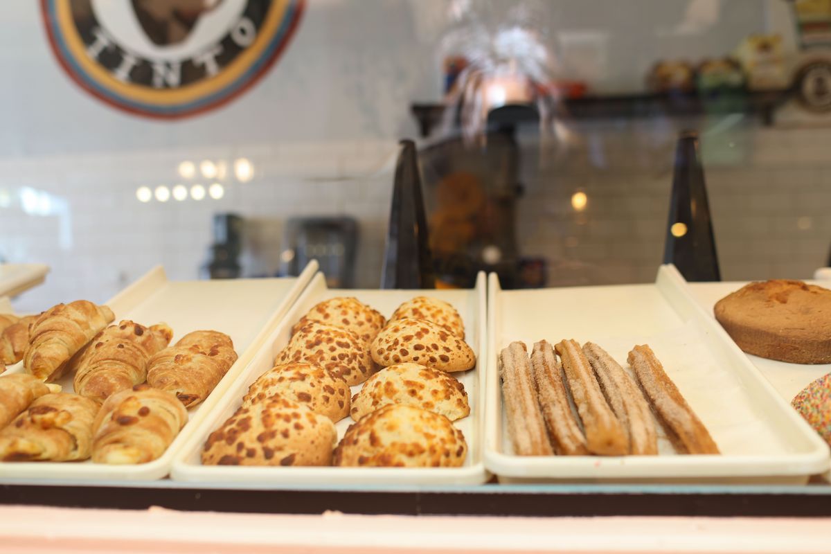 Transparent display case with brown pastries at Cafe Tinto