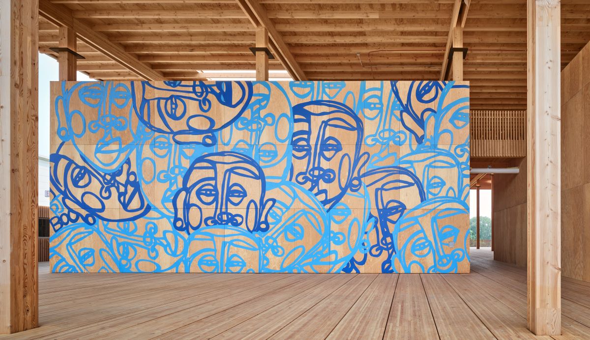 A wall featuring face outlines in dark and light blue. 