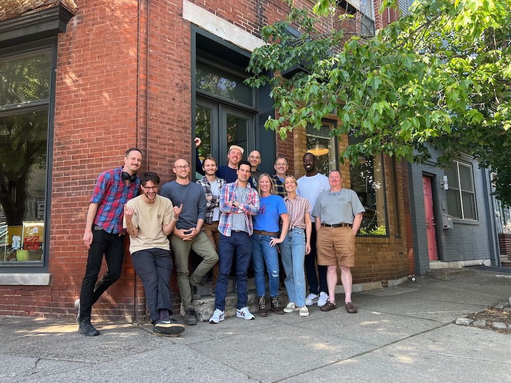 Group photo of the Apostrophe team standing outside a brick building in Philadelphia.