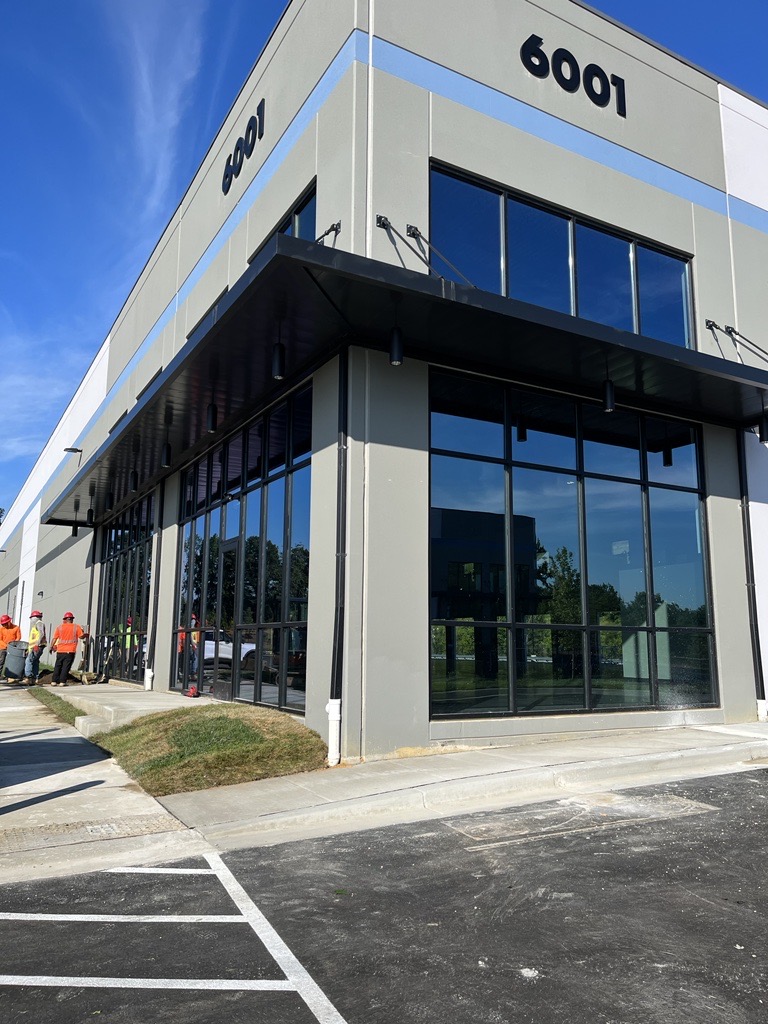 A view of a gray building with large windows. The top reads 6001.