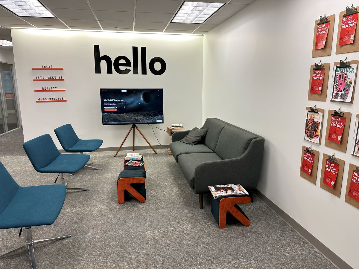 A wall reads 'hello' with a sofa and chairs on the floor below. 