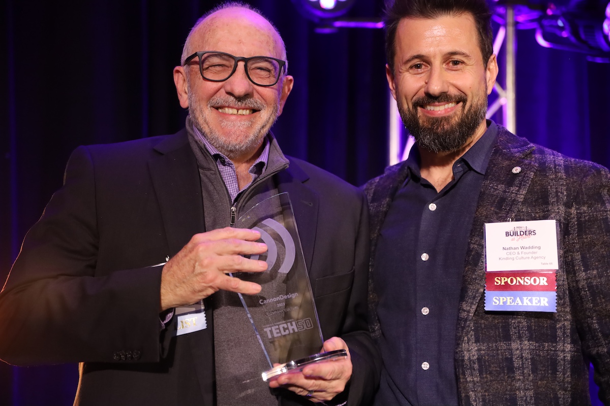 Two men standing next to each other holding an award.