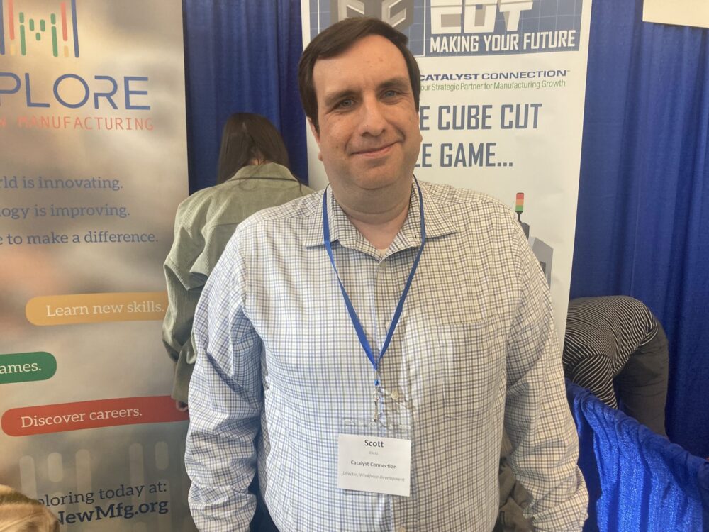 A man standing in front of a booth at a trade show.