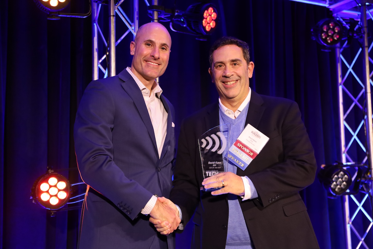 Two men shaking hands at an awards ceremony.