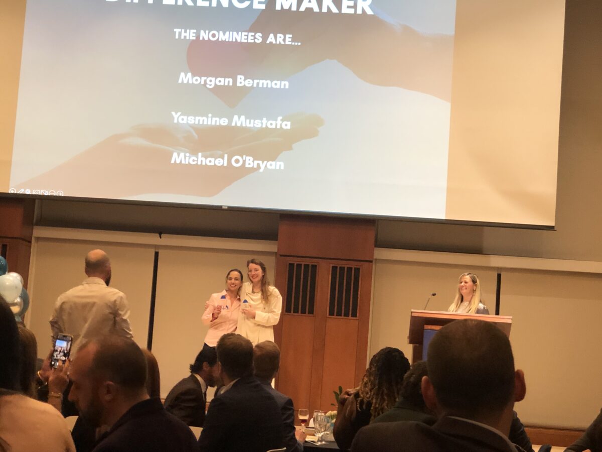 A group of people standing in front of a screen with the words experience maker.