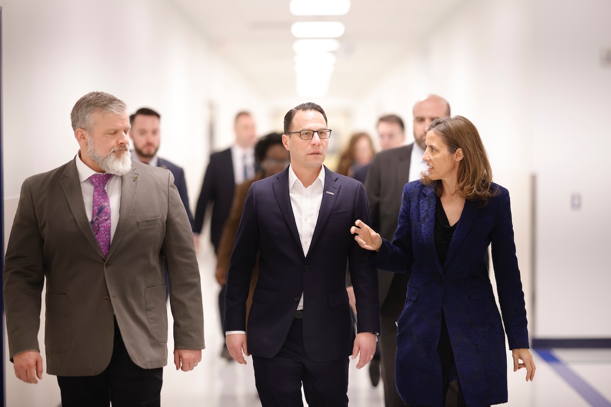 A group of people walking down a hallway.