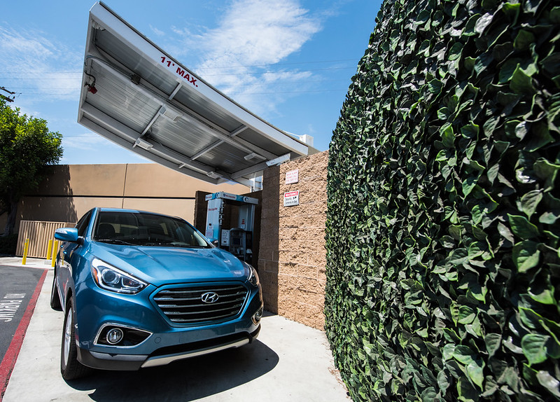 A hydrogen fuel cell vehicle next to a fueling station