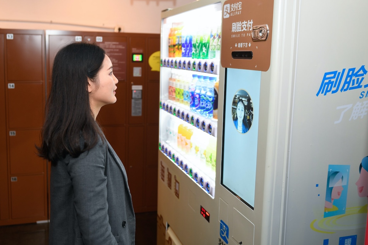 A woman's face is scanned by a vending machine.