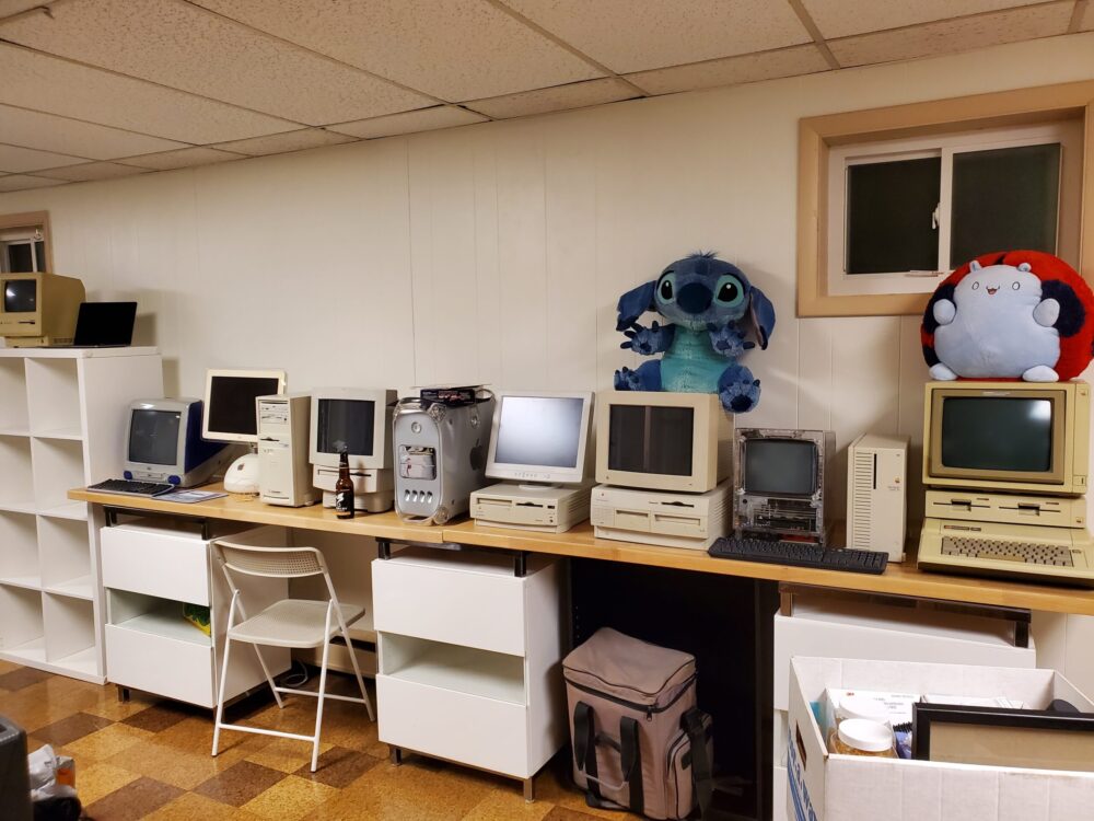 A room with several computers on a desk.