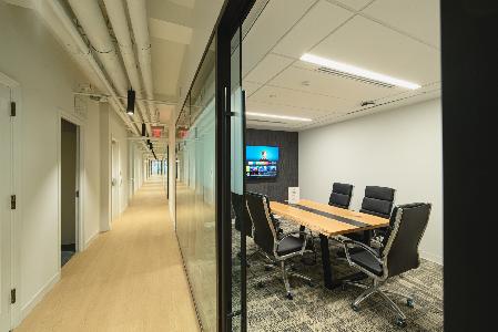 A conference room with a glass wall and chairs.