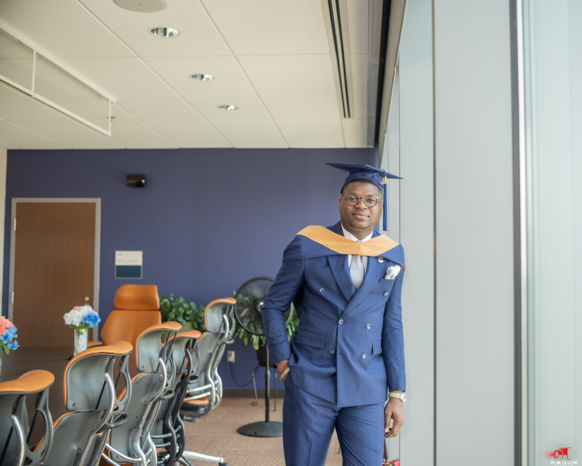Temitope Ajibola in blue suit and commencement cap with gold and blue attire