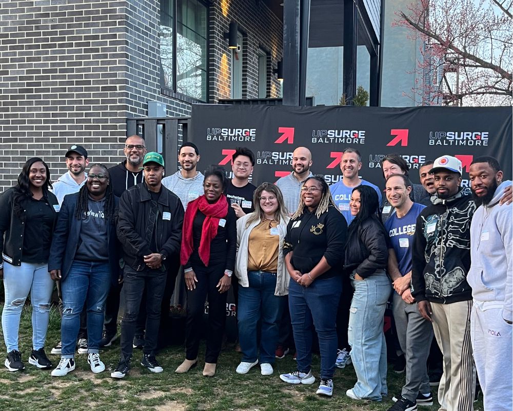 A group of individuals posing for a photo at an UpSurge Baltimore event.