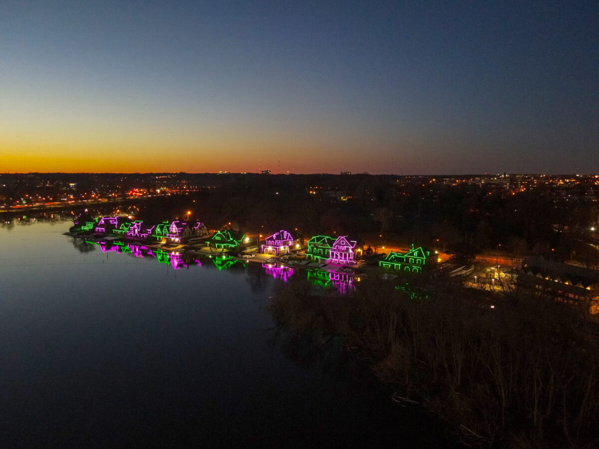 Aerial view of a waterfront with illuminated buildings at twilight.