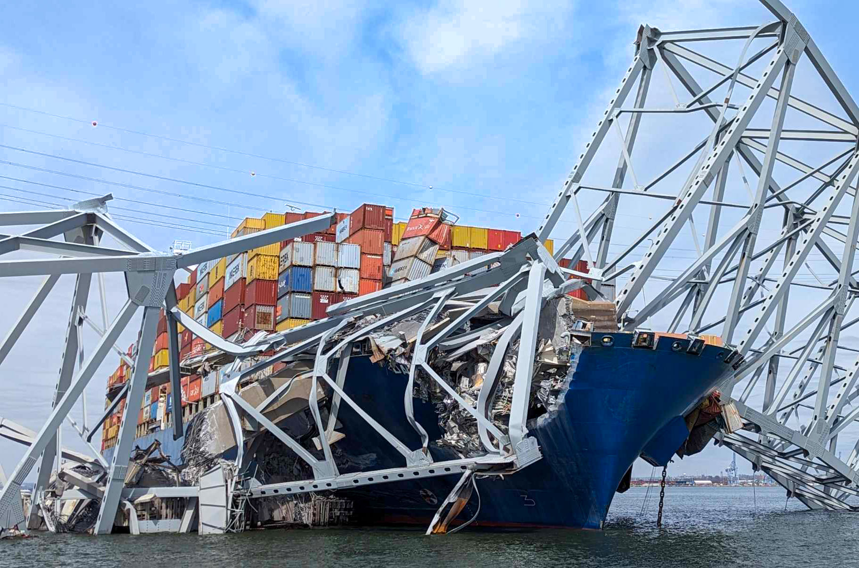 Cargo ship collides with bridge, resulting in structural damage and displaced containers.