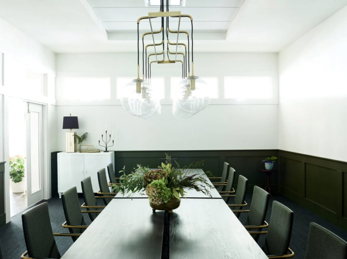 Conference room with a long table, contemporary chairs, and an artistic chandelier.