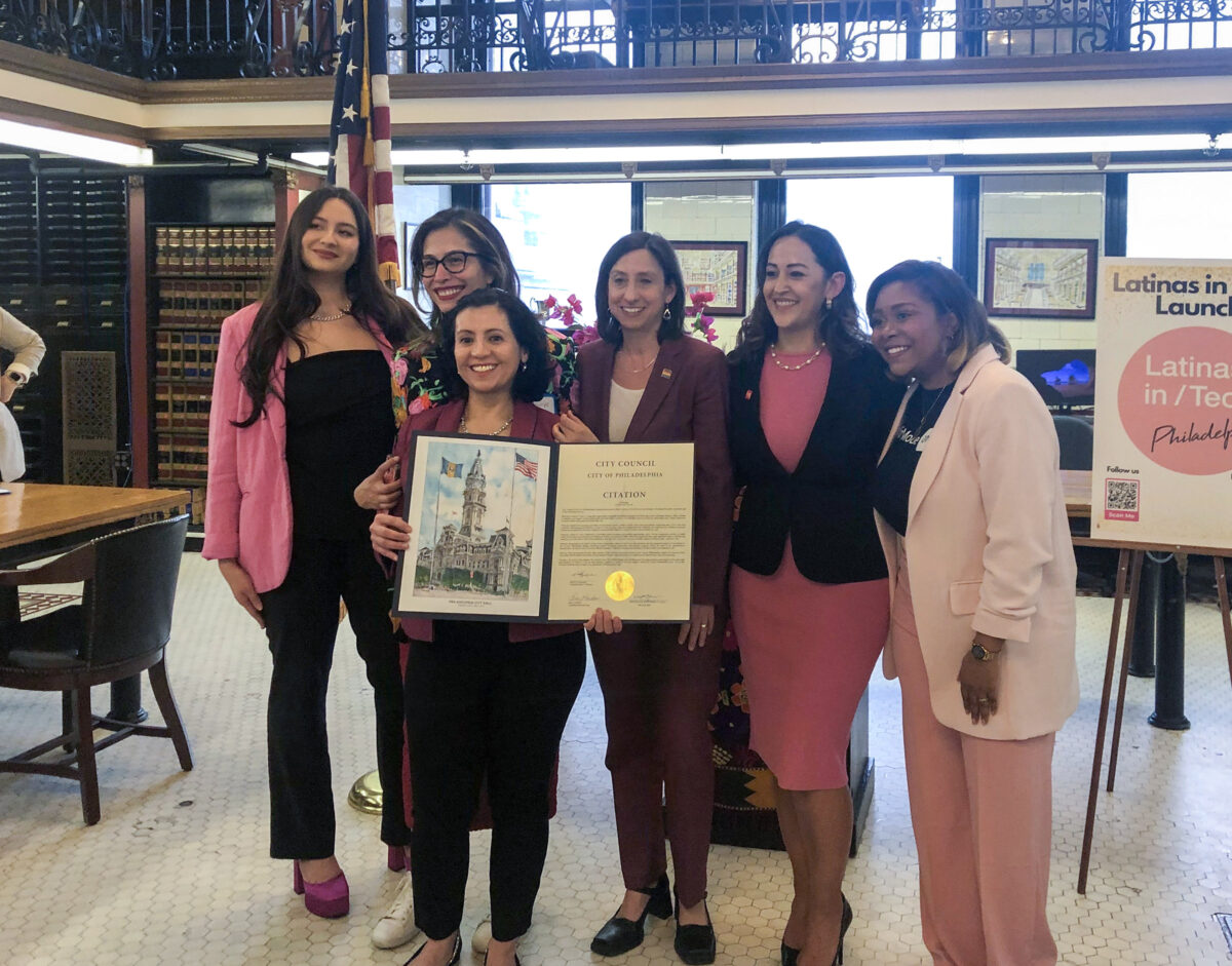 A group of women posing for a picture with an official citation.